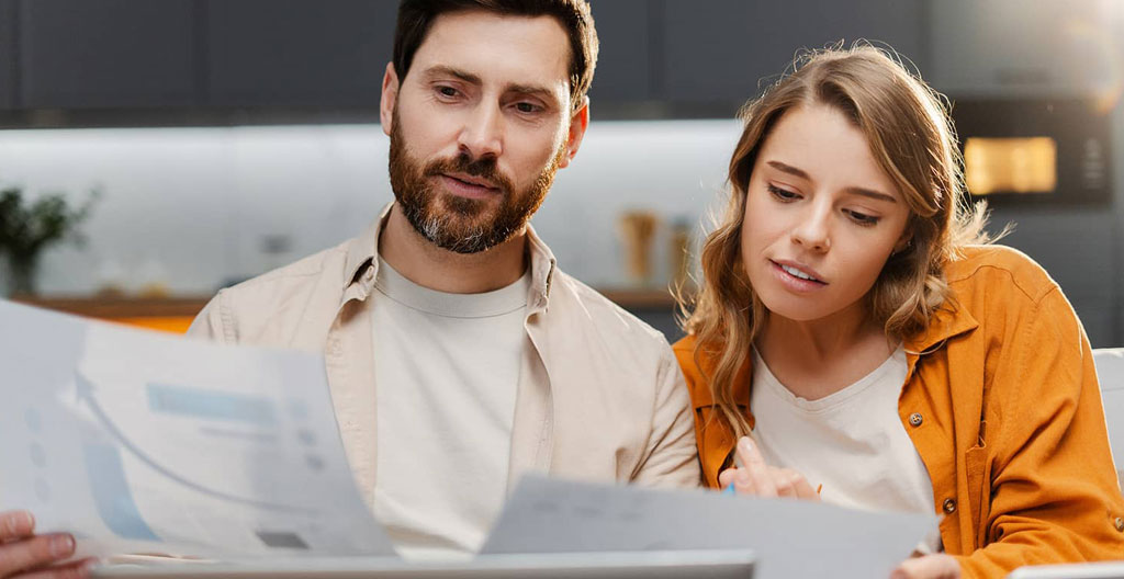 Professionnel utilisant un comparateur d'énergie en ligne sur son ordinateur avec factures de référence